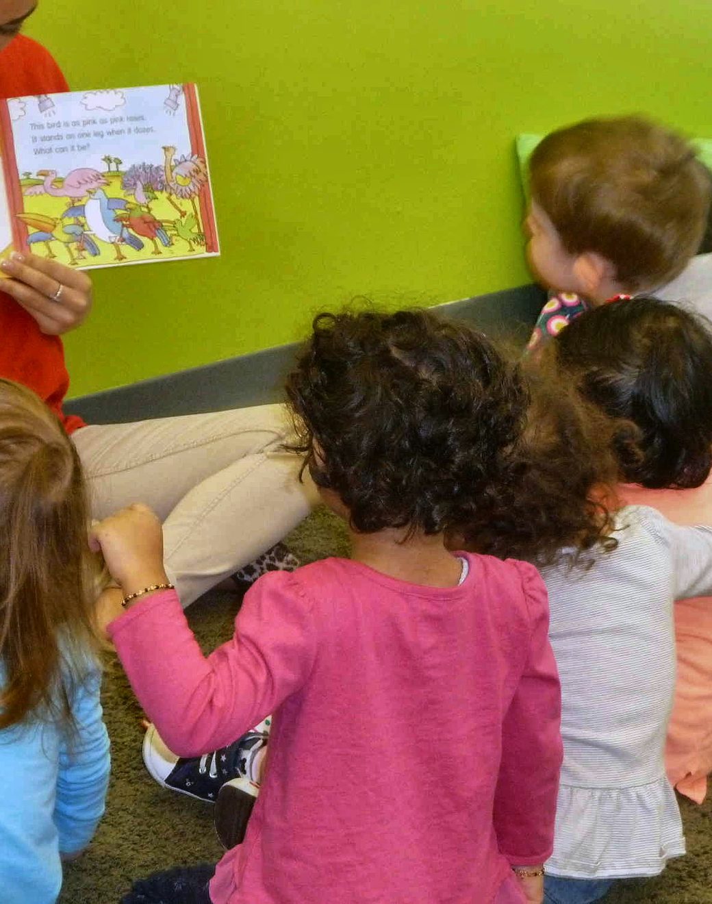 A teacher reading a picture book to a small group of children