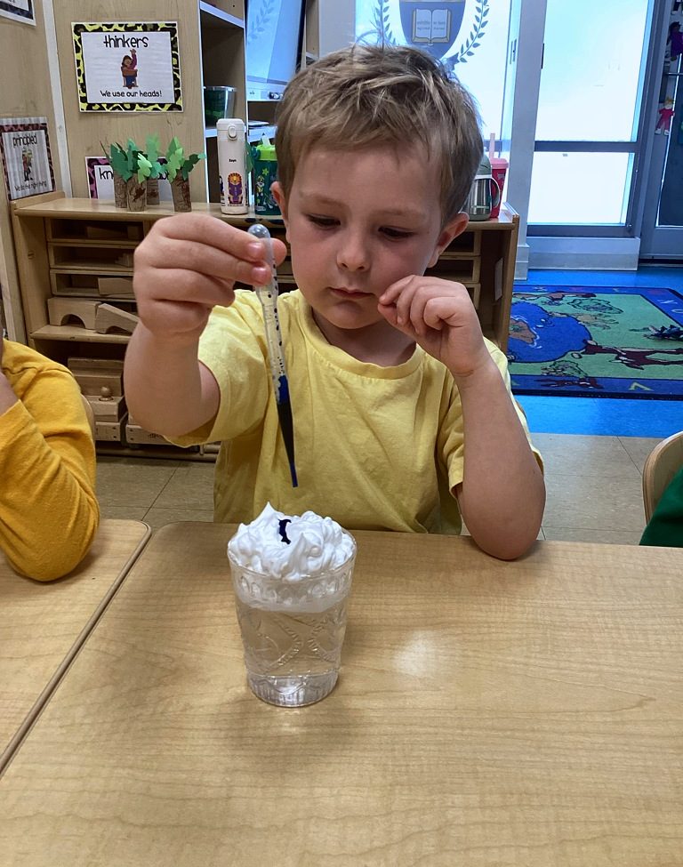 A child exploring a hands-on whipped-cream science experiment