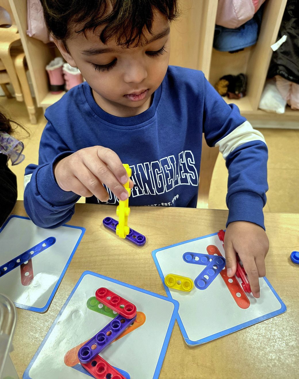 A young boy focused on a hands-on STEM building task