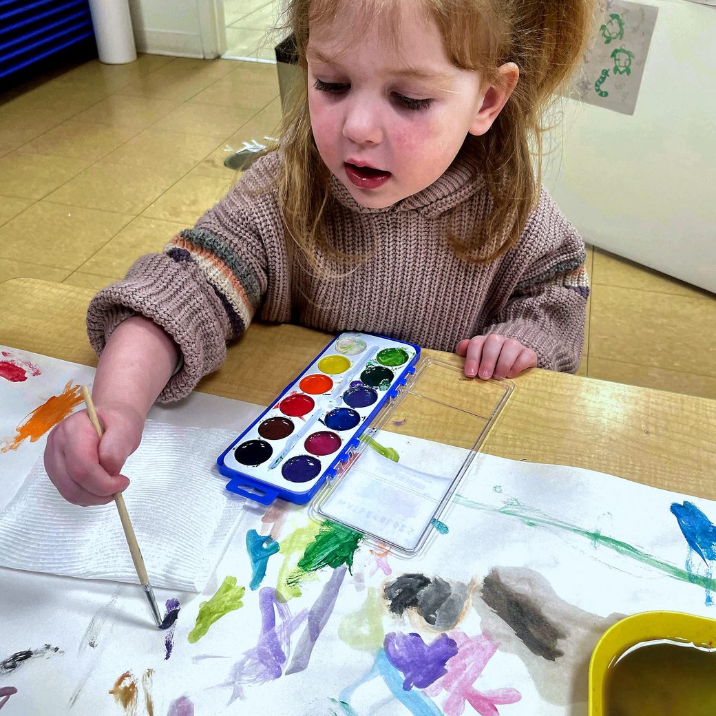 A girl concentrating on a watercolor painting