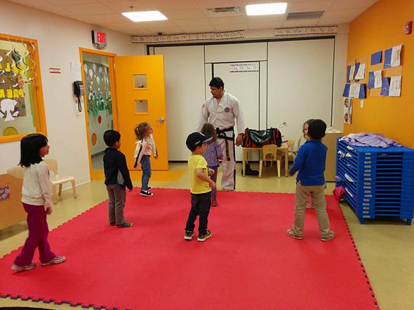 Martial arts instructor leading a children's class on the mats