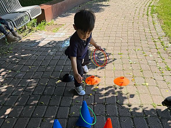 Child practicing footwork with training cones and agility discs outdoors