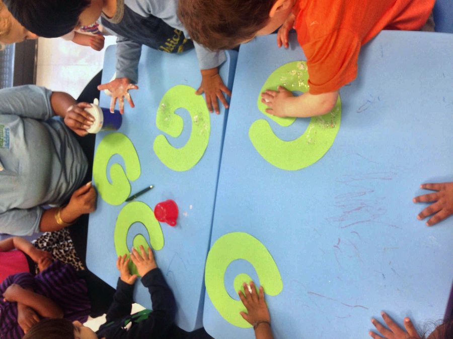 Toddlers working together on a collaborative painting activity