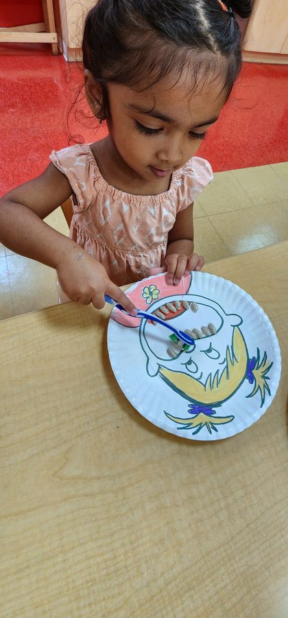 A child decorating a paper-plate fish