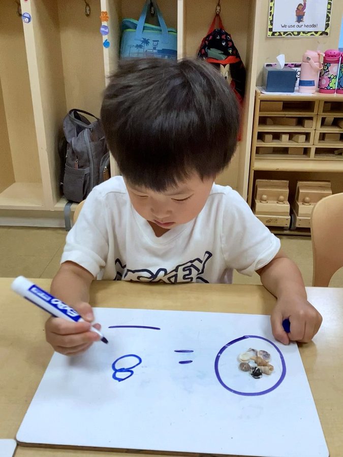 A child practicing writing the numeral eight