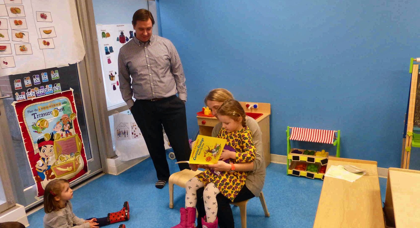 A parent reading together with a child in the classroom